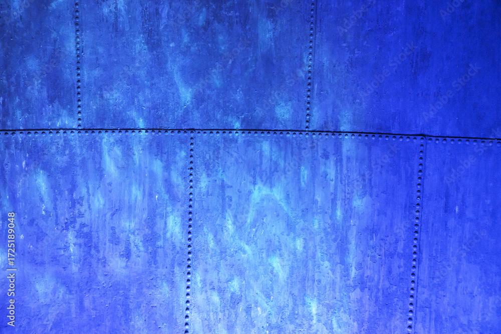 Naklejka premium Blue metal plate with rivets. Closeup