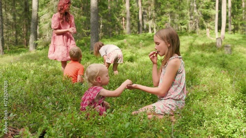 In slow motion, five children collect wild berries in a lush green forest on a sunny summer day, sharing curiosity, teamwork, and nature connection