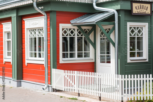 Photos A red-and-green wooden Russian house with white windows