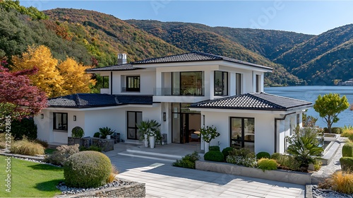 Modern Two-Story Villa with White Walls and Black Tiled Roof in Scenic Landscape