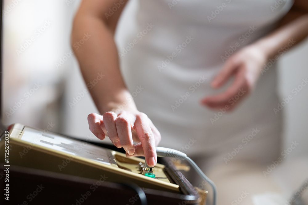 Obraz premium Close up of a therapists hand adjusting the settings on an electrotherapy machine before physiotherapy treatment. Concept of modern rehabilitation, medical technology, and therapeutic healthcare