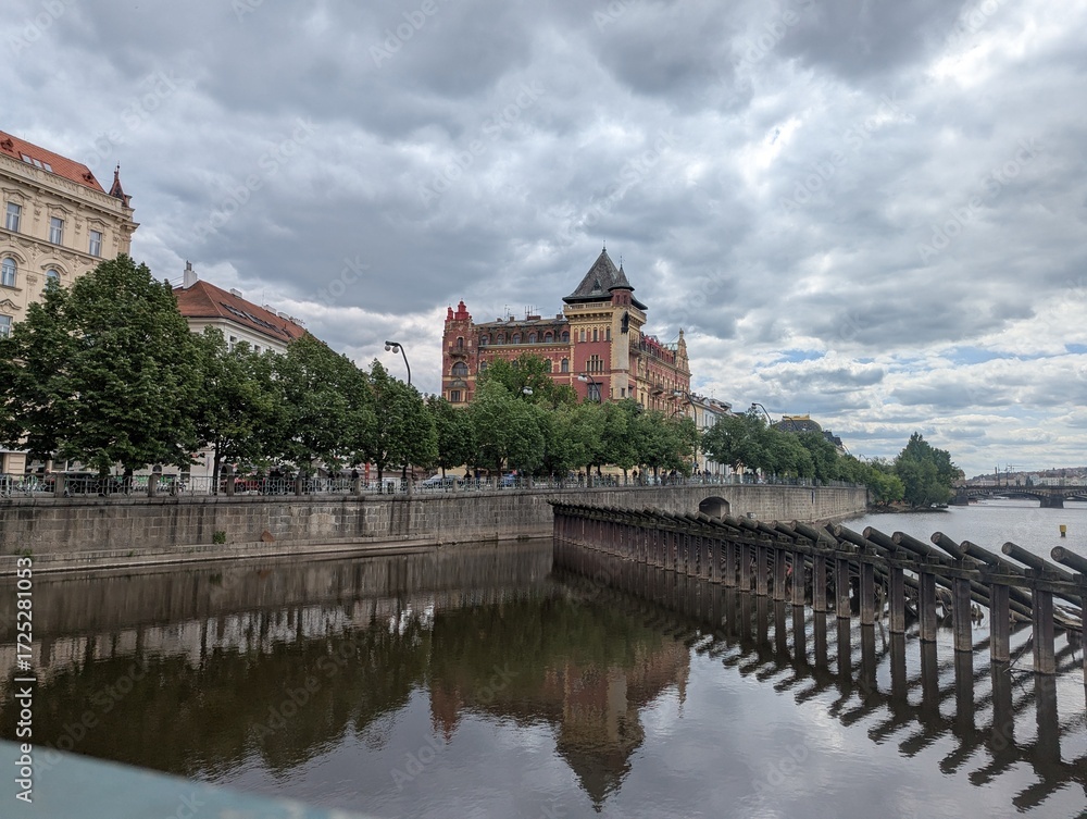 Fototapeta premium Historic riverside architecture and reflections along the Vltava River in Prague