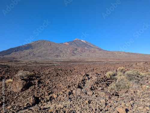 Mount Teide volcano and rocky lava fields under a clear blue sky in Tenerife