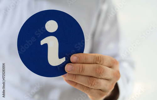 Hand holding a blue circle ...