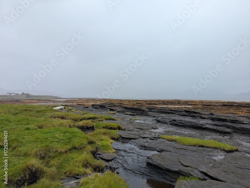 Layered rock pools and grassy shoreline at Broadford on the Isle of Skye Scotland