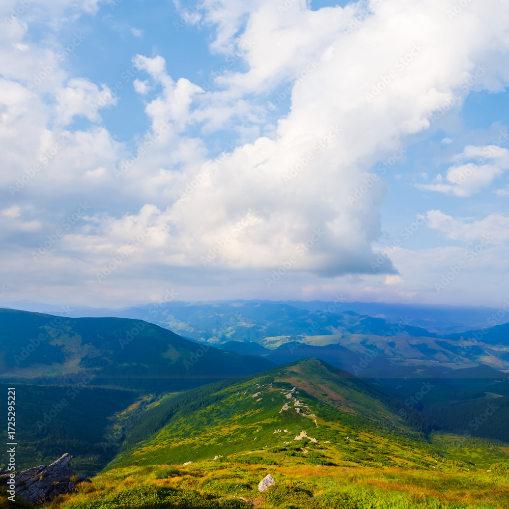 Fototapeta premium green mountain ridge under a blue cloudy sky