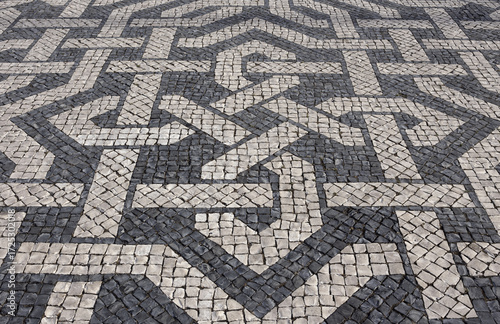 Lisbon, Portugal. Typical Portuguese black and white stone mosaic calcada pavement - found throughout Portugal. Also in Brazil and other previous Portuguese colonies. Interwoven pattern.