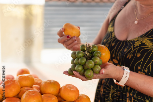 Woman choosing fresh exotic fruit at outdoor market