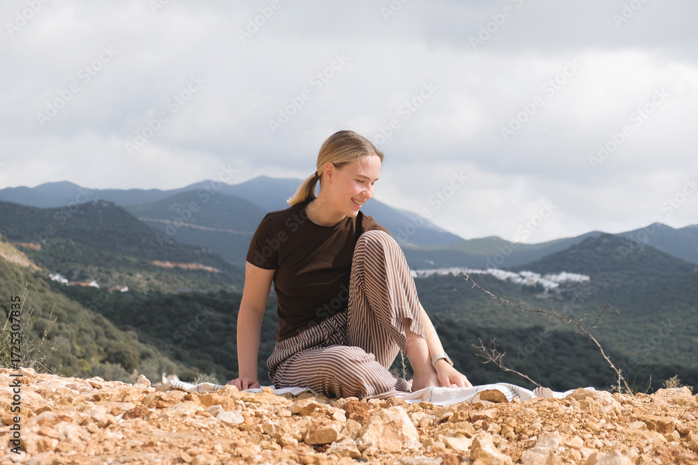 Naklejka premium Mindful mountain retreat: woman meditating outdoors, eyes closed; eco travel, breathwork, slow living, nature connection, inner calm, digital detox