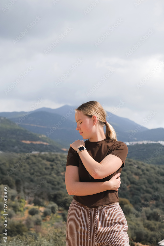 Naklejka premium Mindful mountain retreat: woman meditating outdoors, eyes closed; eco travel, breathwork, slow living, nature connection, inner calm, digital detox