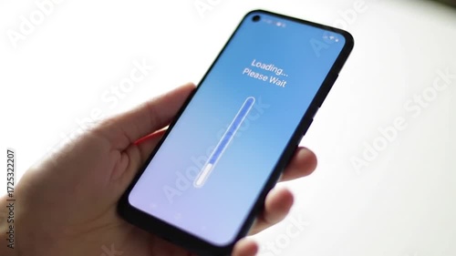 Wallpaper Mural Hand Holding Black Smartphone with Blue Loading Screen Against White Background Torontodigital.ca