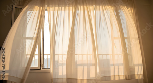 Sheer White Curtains Gently Billowing in a Warm Sunlight-Filled Window