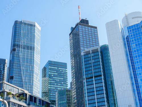 Modern glass skyscrapers in Frankfurt's financial district under a clear blue sky