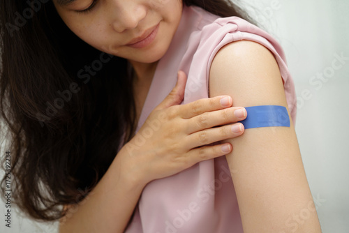 HPV, Human papillomavirus, Asian young woman receiving vaccine with blue bandage.