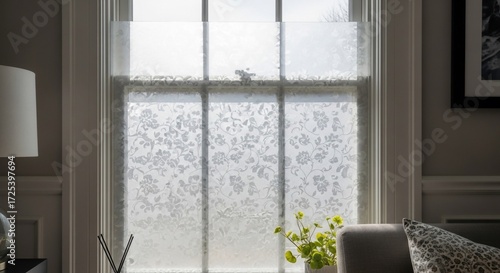 Window with decorative frosted privacy film featuring a floral pattern, allowing diffused light into a room, enhancing home decor.