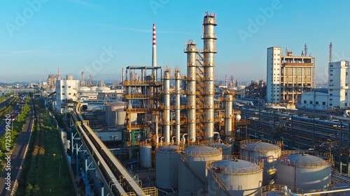 An oil refinery and chemical plant with storage tanks in a large industrial zone at sunrise