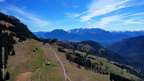 Cinematic 4K Aerial Drone video of flying over Brünnstein mountain in German Alps on a beautiful sunny summer day perfect for hiking with surrounding mountain peaks covered in ice and snow