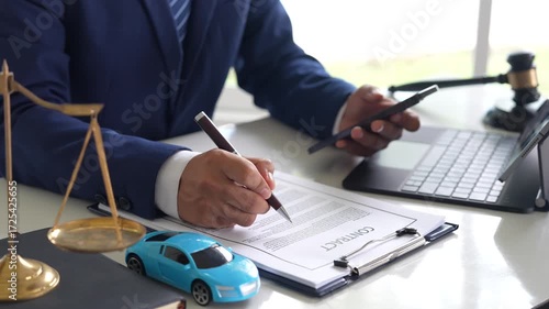 A judge holding a gavel hitting a toy car in a contract document represents automotive law, insurance disputes, car ownership, and legal decisions.