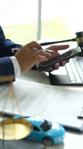A judge holding a gavel hitting a toy car in a contract document represents automotive law, insurance disputes, car ownership, and legal decisions.