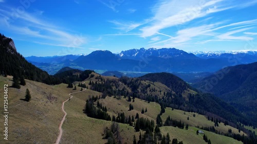 Cinematic 4K Aerial Drone video of flying over Brünnstein mountain in German Alps on a beautiful sunny summer day perfect for hiking with surrounding mountain peaks covered in ice and snow