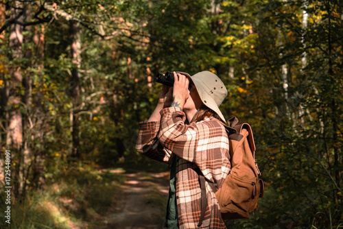 A young man explores the forest and its animals and birds through binoculars