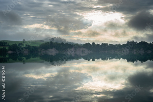 Nebelschwaden und Wolken ziehen bei Sonnenaufgang an der Illasschlucht über den Forggensee, Allgäu, Bayern, Deutschland
