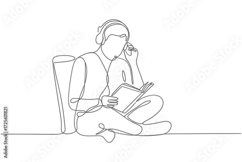 Person wearing headphones reading a book while sitting