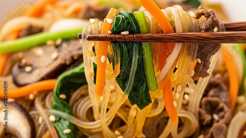 Chopsticks Holding Japchae Noodles with Vegetables