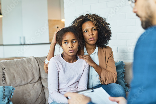 Mother with her teenage daughter at meeting with social worker, psychologist discussing mental health family sitting on sofa in psychotherapist office