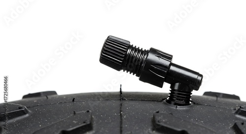 Detail of plastic valve cap on rugged mountain bike tire with knobby tread, inflating off-road bicycle tire for outdoor trail adventures on white background.