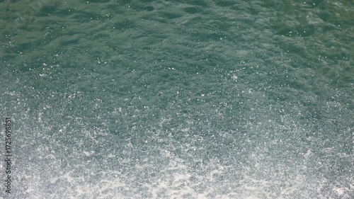 Beautiful waterfall drops splashing on water surface in slow motion calm nature background, perfect abstract video for relaxation, spa, travel, advertising and documentary projects. 120 fps video.