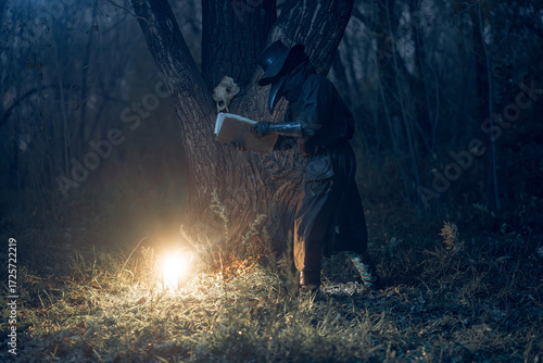 Mysterious figure examines ancient scroll beneath a gnarled tree, illuminated by ethereal light within a dark forest.