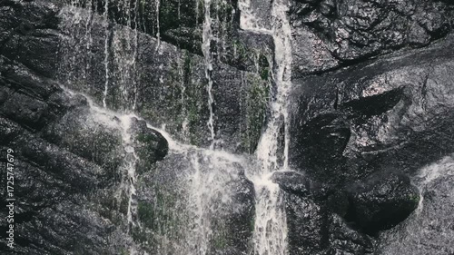 Beautiful waterfall streams flowing down the cliff in slow motion against the background of calm nature, an ideal abstract video for relaxation, spa, travel, advertising projects. Video at 120 fps.