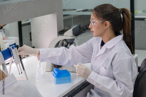 Scientist conducting research in a modern laboratory with a microscope and scientific tools