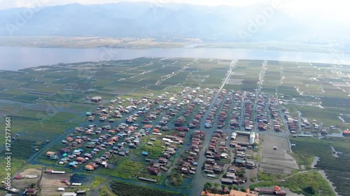 Aerial view of houses on stilts in inle lake, myanmar, with mountains in background