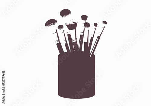 A cup holds a collection of various makeup brushes with different shapes and sizes