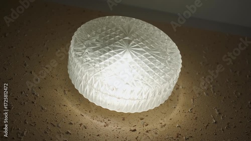 A wall lamp with a round relief shade, close-up