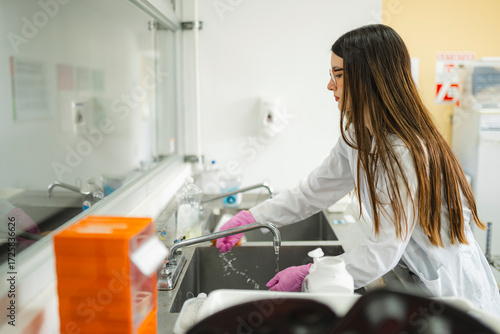 Young female scientist cleaning lab equipment in a university laboratory