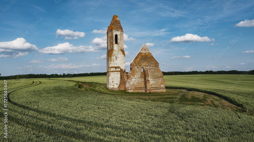 Fototapeta premium Medieval ruined church in the middle of a field. Historical landmark, Romanesque architecture, and a unique sight in nature.