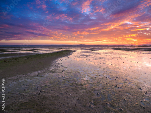 Wallpaper Mural Sunset reflections at Holy Island at low tide Tidal flats reflecting dramatic sunset sky with vibrant clouds and wet sand at low tide Torontodigital.ca