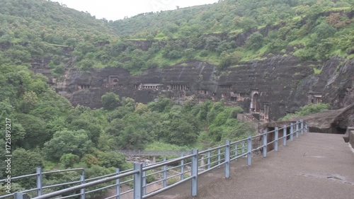 Ancient rock-cut Ajanta Caves nestled into the Sahyadri hill slopes, surrounded by dense seasonal green forests