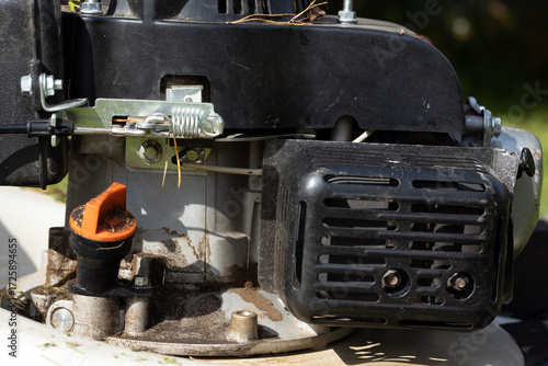 Close-up of a small gasoline engine with visible components like the air filter and fuel line. Ideal for mechanical or gardening themes.
