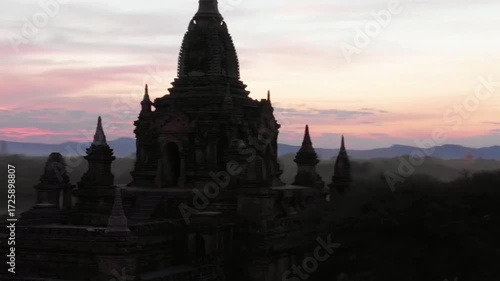 Ancient temples stand silhouetted against a vibrant sunset sky in bagan, myanmar