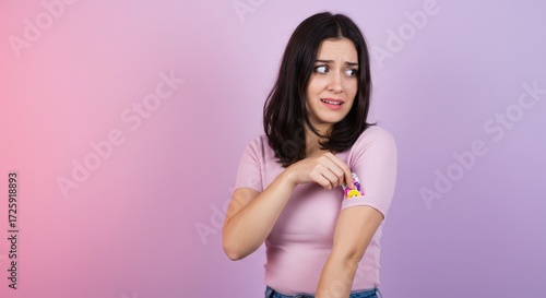 Concerned woman concealing a small, colorful toy inside her shirt sleeve