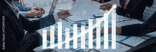 Business professionals engaged in analysis of financial reports with digital graphs, illustrating growth and performance metrics during collaborative meeting. Axiom
