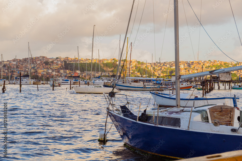 Fototapeta premium Seaport with yachts and white boats in a city at sunset, cloudy sky. Brazil, Salvador Bahia