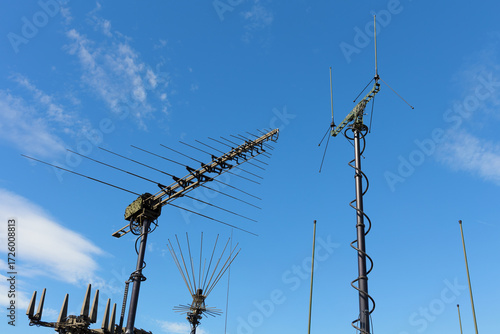 Various military antennas, transmitters and receivers for radio communication and transmission. Equipment, devices and technology used by signal corps. Blue sky as copy space.