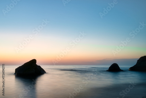 Close up view of the Black Sea at sunset in Georgia with rocks in the water, perfect for travel, tourism, and nature themes.