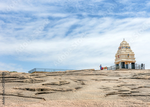 Bangalore, Karnataka, India - October 5, 2013: Lal Bagh Botanical Garden. Exposed gneiss hillock ancient rock formation with one of the 4 Cardinal towers of the city, a Hindu religious site