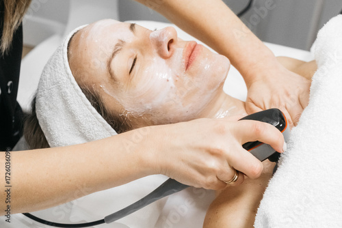 Fotografie Caucasian woman receiving RF lifting treatment for facial rejuvenation, relaxing